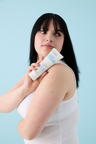 woman holding cream for keratosis pilaris, chicken skin, rough spots on arms
